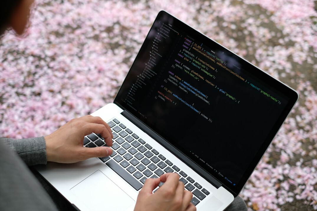 programmer coding on laptop